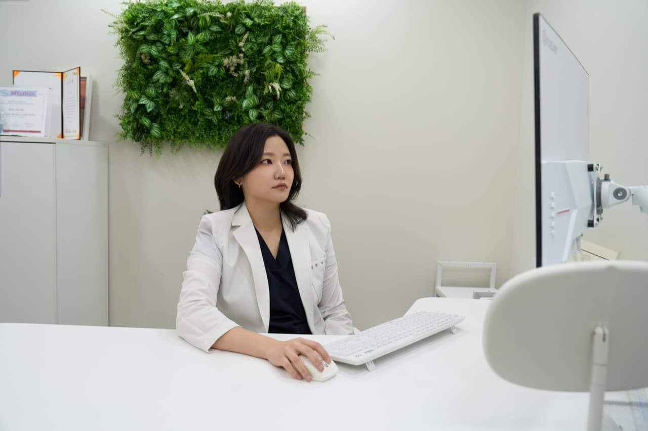 李有真院長在診間看著螢幕準備診療